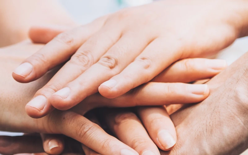 Nahaufnahme von freiwilligen teamwork Leuten, die den Finger auf sternförmige Hände legen