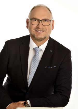 Erster Bürgermeister Richard Kammerer mit weißem Hemd, blauer Krawatte und schwarzem Sakko mit Brille